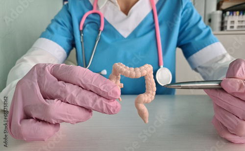 Anatomical model of the intestine with pathology in hands of doctor