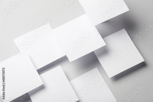 Composition of floating white square memo papers on gray background. Business concept