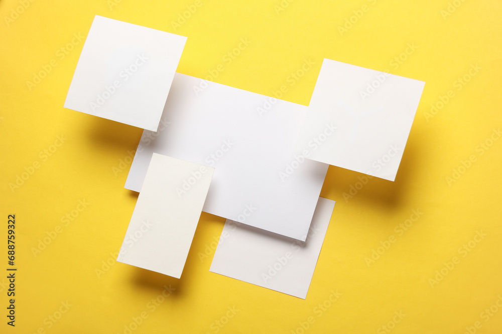 Composition of floating white square memo paper and cards on yellow background. Mockup. Business concept - obrazy, fototapety, plakaty 