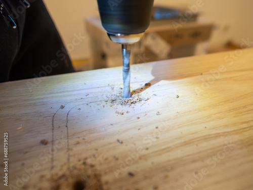 Drilling a hole in a kitchen worktop. Building and modifying furniture at home to have a place to cook food. Domestic environment when moving into a new apartment or renovation the own flat.