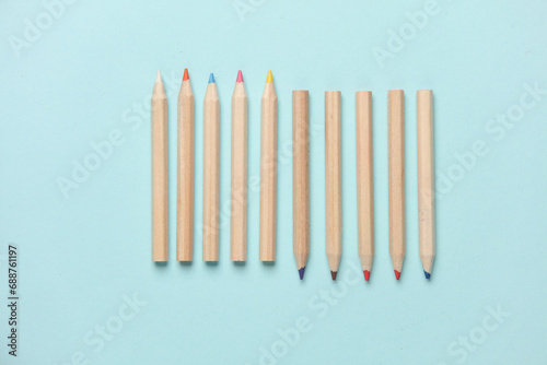 Set of wooden colored pencils on a blue background. Creativity, art