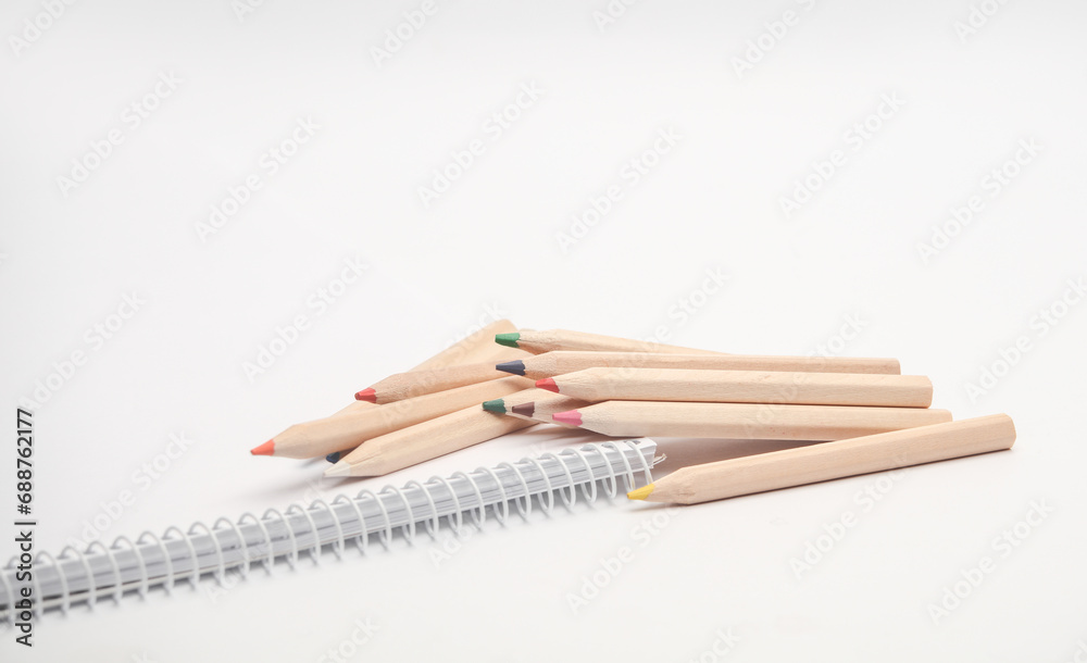 Obraz premium Wooden colored pencils and sketchbook on white background. Creativity, art