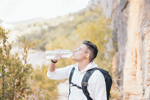 Thirsty man drinking water on mountain photo