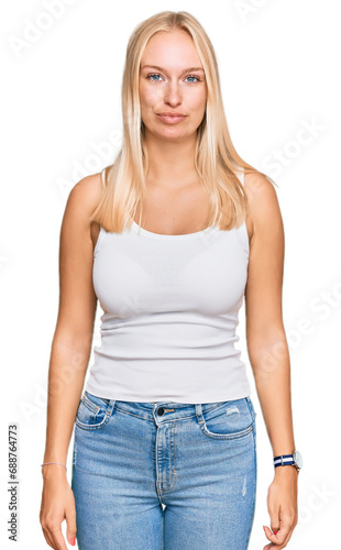 Young blonde girl wearing casual style with sleeveless shirt looking sleepy and tired, exhausted for fatigue and hangover, lazy eyes in the morning. © Krakenimages.com