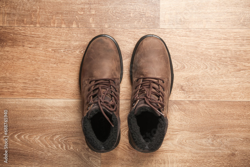 Men's leather winter boots on a wooden floor. Top view