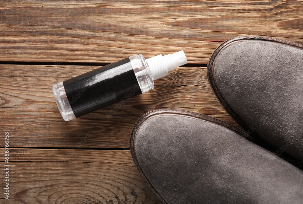 Suede boots and water protection spray on wooden floor