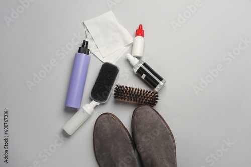 Fototapeta Naklejka Na Ścianę i Meble -  Suede chelsea boots with Shoe care products and accessories on gray background. Flat lay