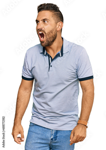 Handsome man with beard wearing casual clothes angry and mad screaming frustrated and furious, shouting with anger. rage and aggressive concept.