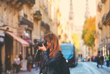 Photographer taking photo on street with tram rails and Saint Andre Cathedral in Bordeaux, France