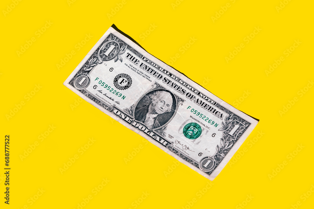 Closeup of one dollar paper currency isolated on yellow background with copy space Closeup of one dollar paper currency isolated on yellow background with copy space
