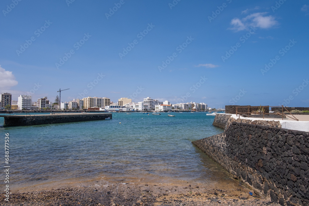 Seascape. View of the city of Arrecife from the Fermina islet. White sand beach and jetty. Lanzarote, Canary Islands, Spain.