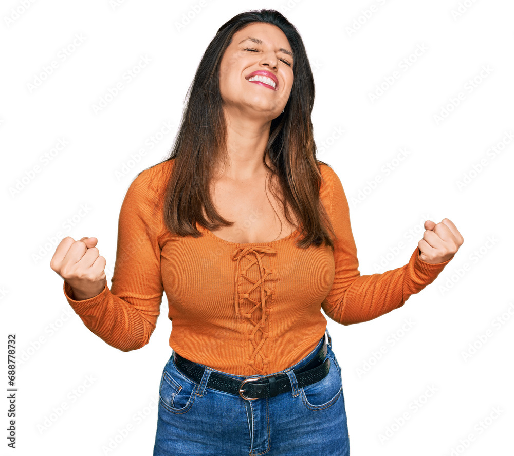 Beautiful hispanic woman wearing casual clothes very happy and excited doing winner gesture with arms raised, smiling and screaming for success. celebration concept. Beautiful hispanic woman wearing casual clothes very happy and excited doing winner gesture with arms raised, smiling and screaming for success. celebration concept.