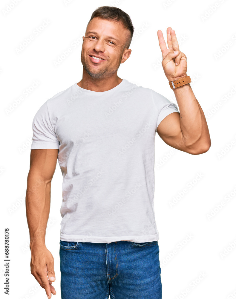 Handsome muscle man wearing casual white tshirt showing and pointing up with fingers number three while smiling confident and happy. Handsome muscle man wearing casual white tshirt showing and pointing up with fingers number three while smiling confident and happy.