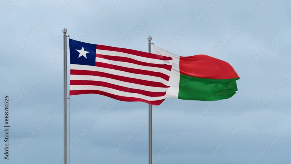 Madagascar flag and Liberia flag waving together on cloudy sky, endless seamless loop, two country relations concept Madagascar flag and Liberia flag waving together on cloudy sky, endless seamless loop, two country relations concept