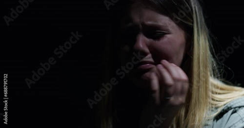 Woman, trauma and kidnapping victim crying with stress, fear and danger for terrorism and horror. Scared girl, ransom and young female hostage in crisis, prison and frustrated for help in dark room. photo