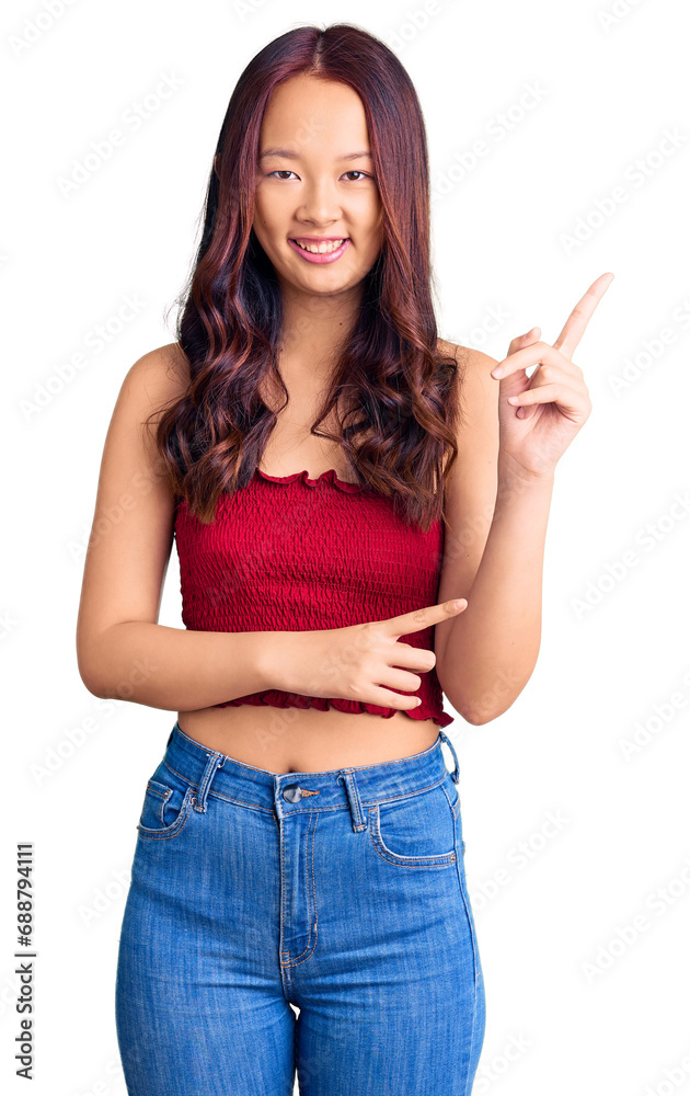 Young beautiful chinese girl wearing casual clothes smiling and looking at the camera pointing with two hands and fingers to the side. Young beautiful chinese girl wearing casual clothes smiling and looking at the camera pointing with two hands and fingers to the side.