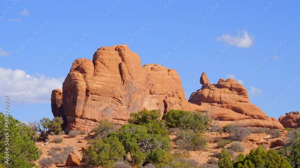 Establishing shot of mountain trail with red rocks background in Double Arch, Arches National Park, Utah, North America. Day time on October 2023. Still camera view. ProRes 422 HQ. Establishing shot of mountain trail with red rocks background in Double Arch, Arches National Park, Utah, North America. Day time on October 2023. Still camera view. ProRes 422 HQ.