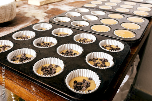 Tray with uncooked cupcakes on table photo