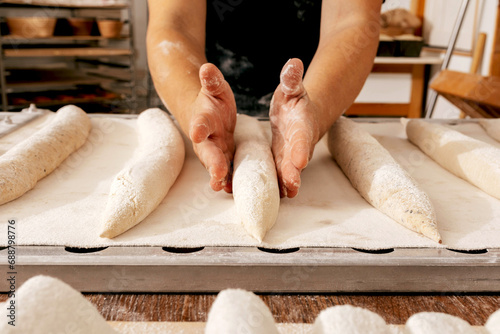 Hands of man making bread in bakehouse photo