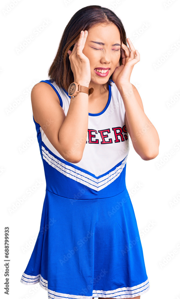 Young beautiful chinese girl wearing cheerleader uniform with hand on head, headache because stress. suffering migraine. Young beautiful chinese girl wearing cheerleader uniform with hand on head, headache because stress. suffering migraine.