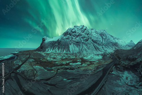 Majestic Northern Lights Over Snowy Icelandic Peak photo