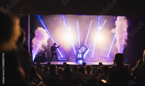 Crowd of people watching magical performance on stage photo