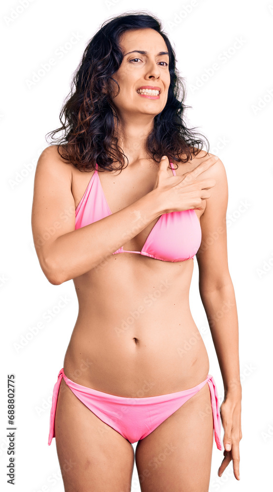 Young beautiful hispanic woman wearing bikini pointing aside worried and nervous with forefinger, concerned and surprised expression Young beautiful hispanic woman wearing bikini pointing aside worried and nervous with forefinger, concerned and surprised expression