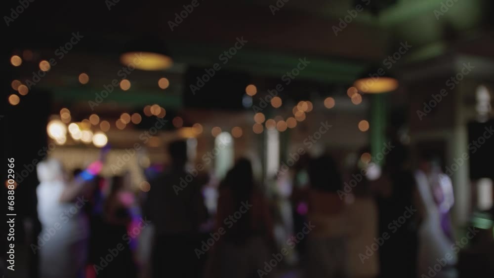 Defocused view of great wedding party with silhouettes of people dancing on the dancefloor. Slow motion. Defocused view of great wedding party with silhouettes of people dancing on the dancefloor. Slow motion.
