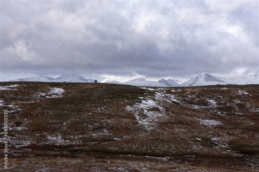 Two people walking in mountains of Scottish Highlands