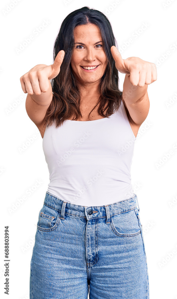 Young beautiful brunette woman wearing casual sleeveless t-shirt approving doing positive gesture with hand, thumbs up smiling and happy for success. winner gesture. Young beautiful brunette woman wearing casual sleeveless t-shirt approving doing positive gesture with hand, thumbs up smiling and happy for success. winner gesture.