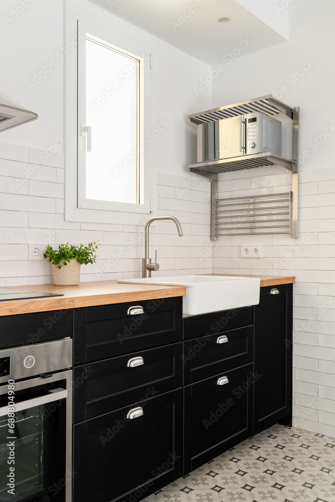 Silver microwave oven, sink and cabinets in modern kitchen Silver microwave oven, sink and cabinets in modern kitchen