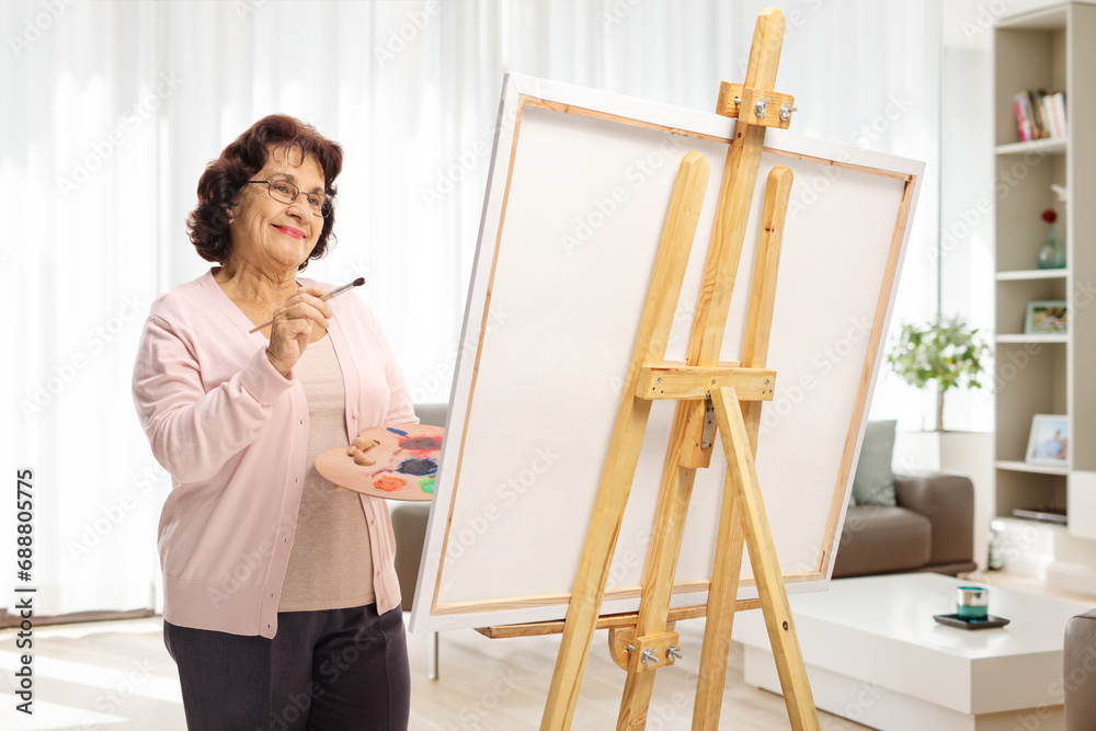 Elderly woman painting on a canvas Elderly woman painting on a canvas