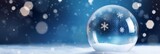 Empty shiny Snow Globe, Christmas magic ball, on blue snowy background with copy space.