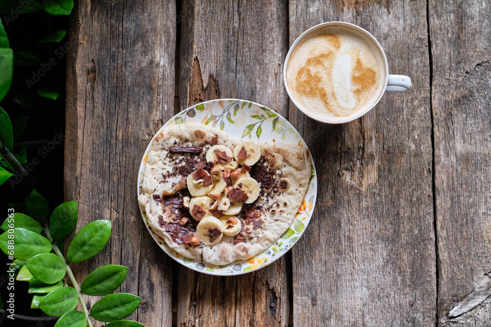 Homemade flatbread with chocolate and bananas on a wooden background. Homemade flatbread with chocolate and bananas on a wooden background.