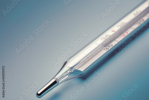 mercury thermometer close-up on a blue background photo