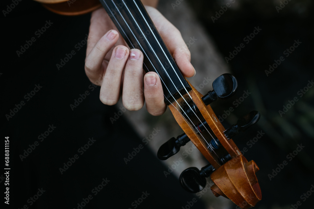 Violinist's hands holding bow and playing the violin close-up Violinist's hands holding bow and playing the violin close-up