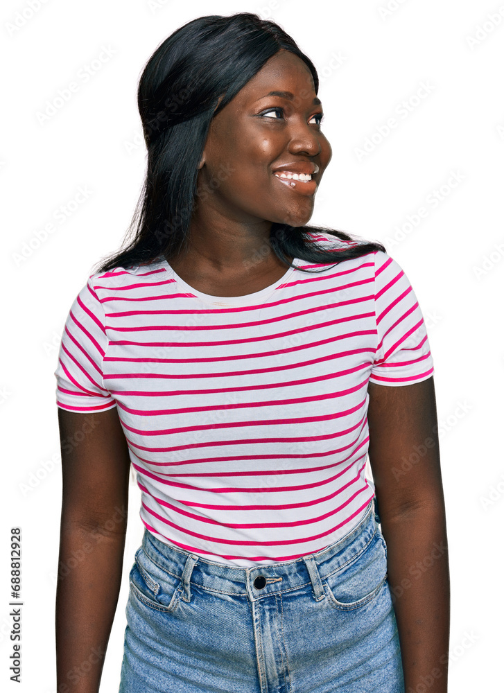African young woman wearing casual striped t shirt looking away to side with smile on face, natural expression. laughing confident. African young woman wearing casual striped t shirt looking away to side with smile on face, natural expression. laughing confident.