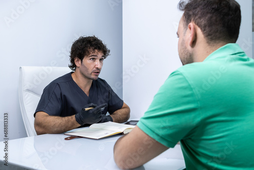 Nurse in a private clinic is talking to his patient who is sitting in front of him.