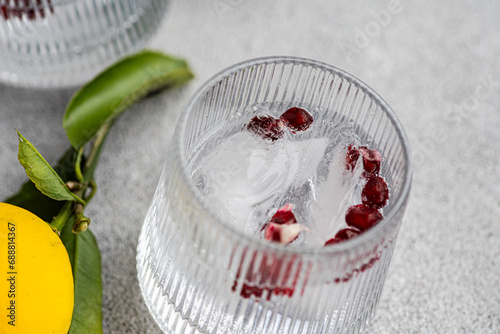 Refreshing gin tonic with ice and lemon on gray background photo