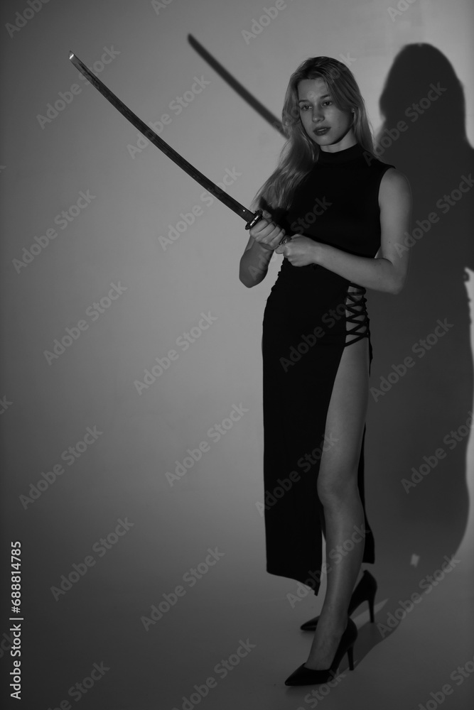 Young lady with katana sword in black and white Young lady with katana sword in black and white