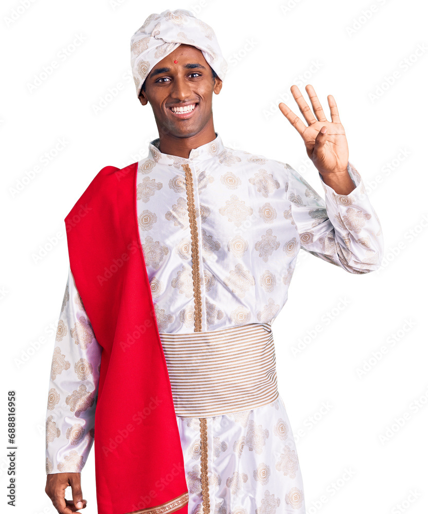 African handsome man wearing tradition sherwani saree clothes showing and pointing up with fingers number four while smiling confident and happy.