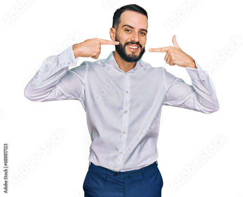 Young man with beard wearing business shirt smiling cheerful showing and pointing with fingers teeth and mouth. dental health concept.