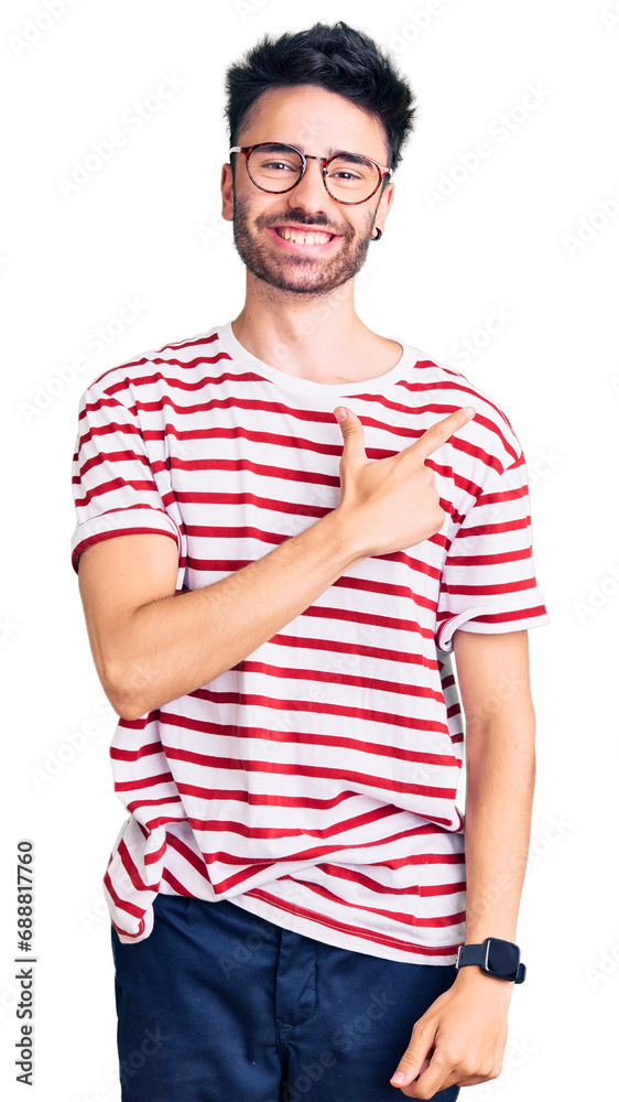 Obraz premium Young hispanic man wearing casual clothes cheerful with a smile on face pointing with hand and finger up to the side with happy and natural expression