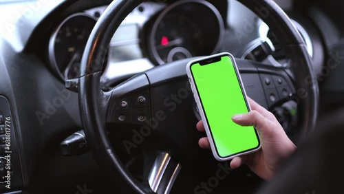 Close up of a man's hand holding a mobile telephone with a vertical green screen in car chroma key smartphone technology cell phone street touch message display hand. photo