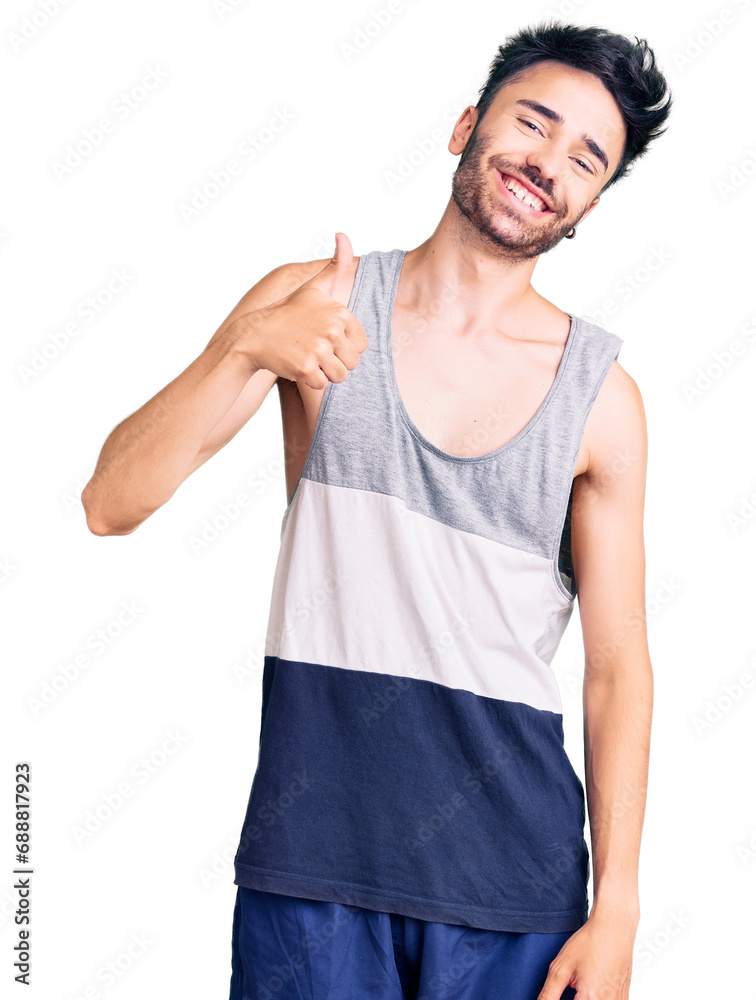 Young hispanic man wearing casual clothes doing happy thumbs up gesture with hand. approving expression looking at the camera showing success. Young hispanic man wearing casual clothes doing happy thumbs up gesture with hand. approving expression looking at the camera showing success.