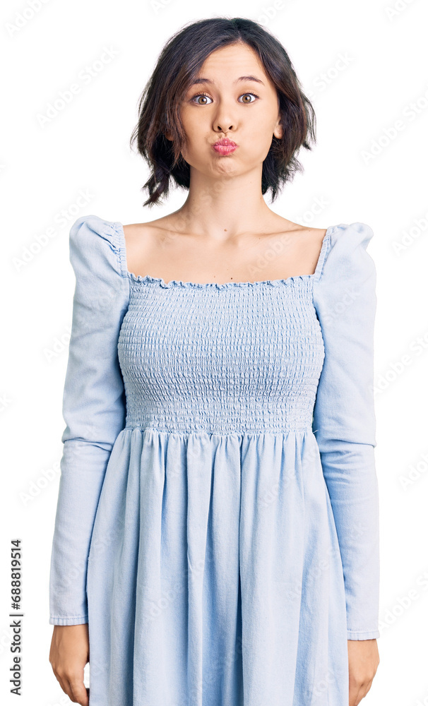Young beautiful girl wearing casual clothes puffing cheeks with funny face. mouth inflated with air, crazy expression. Young beautiful girl wearing casual clothes puffing cheeks with funny face. mouth inflated with air, crazy expression.