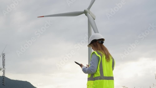 Wallpaper Mural The engineer carefully analyzes the data on the tablet next to a powerful windmill that produces green electricity. Project Manager in Focus at the Wind Turbine with Digital Tablet: Planning for a Torontodigital.ca