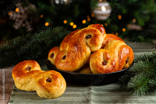 Homemade swedish St Lucia saffron buns. Also called lussekatt or lussebulle, Cornish tea treat bun or revel bun, is a spiced yeast-leavened sweet bun with raisins. Christmas tree.