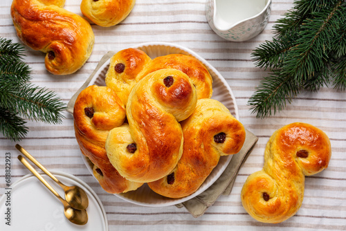 Homemade  swedish St Lucia saffron buns. Also called  lussekatt or lussebulle, Cornish tea treat bun or revel bun, is a spiced yeast-leavened sweet bun with raisins. Christmas decoration, top view. photo