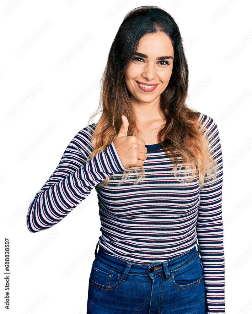 Beautiful hispanic woman wearing casual striped shirt doing happy thumbs up gesture with hand. approving expression looking at the camera showing success. Beautiful hispanic woman wearing casual striped shirt doing happy thumbs up gesture with hand. approving expression looking at the camera showing success.